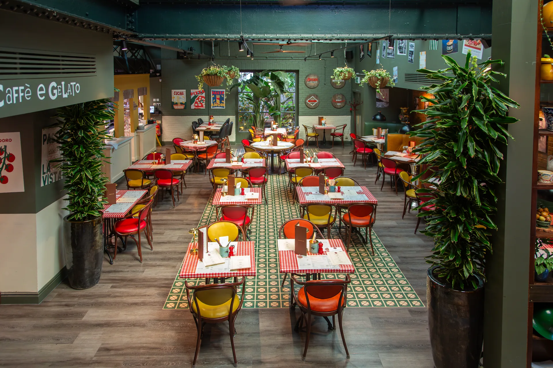 The dining room at The Fire Station Social Cucina, Alderley Edge — rows of tables under a glass roof